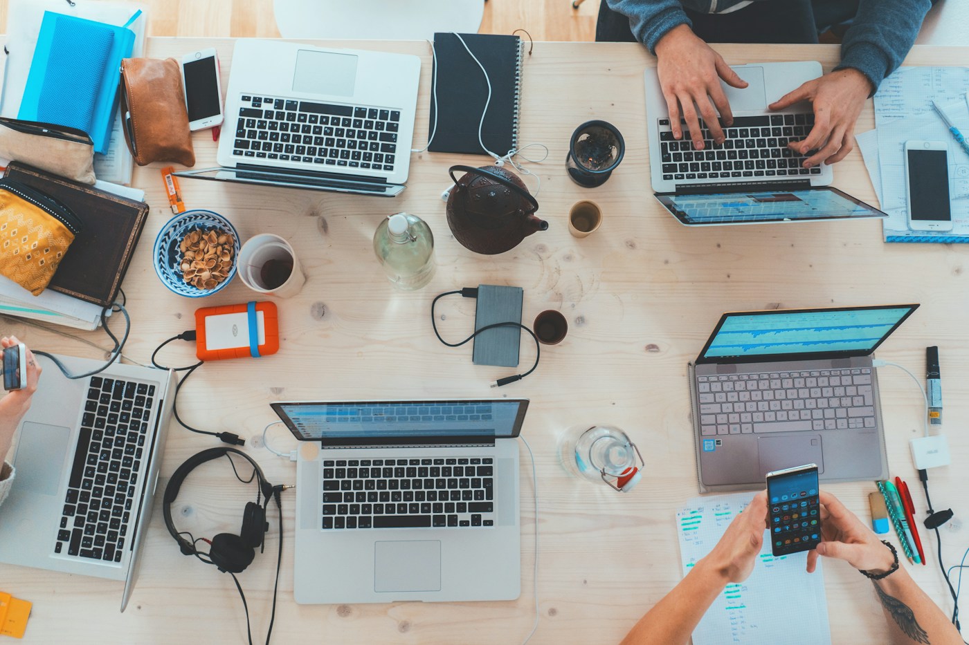 Mesa compartilhada com computadores e materiais de trabalho